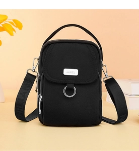 Close-up of black Oxford cloth crossbody bag with silver metal plate and fabric strap