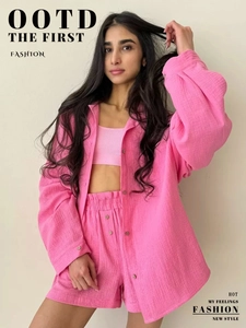 Detail of pink three-piece set with long-sleeve shirt, crop top, and shorts in crinkle fabric