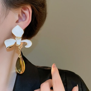 Detail of flower tassel earring with amber teardrop pendant worn on model
