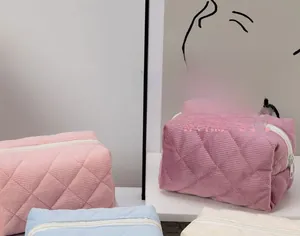 Quilted corduroy cosmetic bags in various colors on a clean white display surface