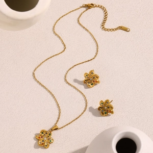 Détail d'un ensemble collier et boucles d'oreilles fleur plaqué or 18 carats en inox