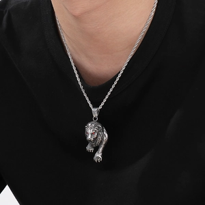 Close-up of silver lion king pendant with red eyes on twist chain for men