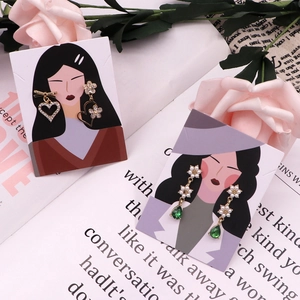 Detailed display of heart and pearl earrings on goddess illustrated cardboards