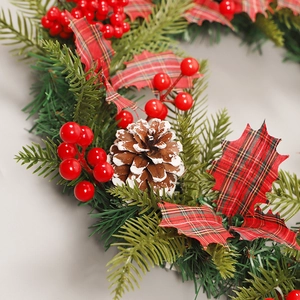 Couronne de Noël avec baies rouges, pommes de pin et rubans à carreaux pour décoration
