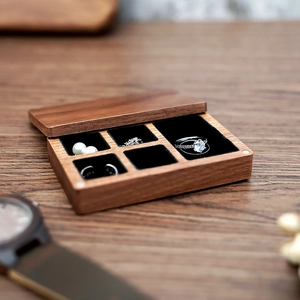 Detail view of walnut wood jewelry box with ring slots and black velvet lining