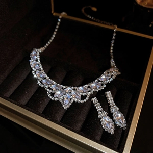 Macro shot of silver teardrop necklace and earrings set with rhinestones in a velvet box
