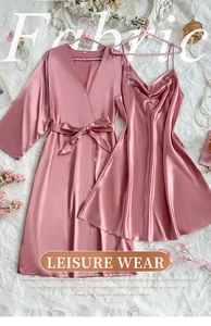 Detailed flat lay of pink satin sleepwear set with robe and slip dress on plush rug