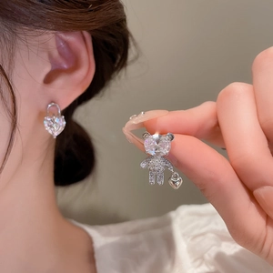 Detail of silver bear and heart stud earrings with sparkling cubic zirconia stones