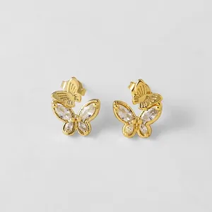 Détail de boucles d'oreilles papillon dorées serties de cristaux taille marquise