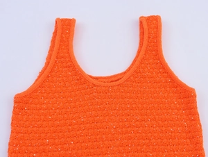 Nahaufnahme der orangefarbenen Strickweste mit Stoffstruktur und Pailletten-Details