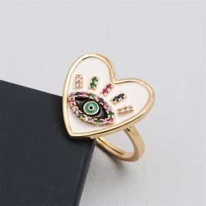 Macro view of gold heart evil eye ring with colorful zircon and enamel inlay details