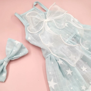Detail of light blue pet dress with white star patterns and a matching mesh bow set