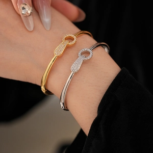 Close-up of gold and silver bangle with zircon buckle detail on model's wrist