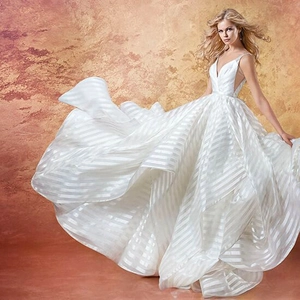 Dettaglio dello scollo a V profondo e della trama a strisce dell'abito da sposa bianco
