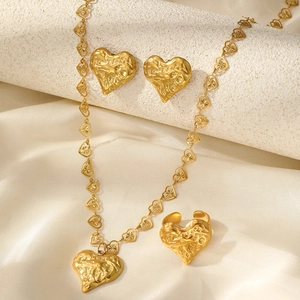 Detailed view of gold lava texture heart-shaped necklace, earrings and ring jewelry set