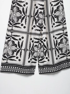 Détail du pantalon large à imprimé floral noir et blanc avec texture en coton et lin fin