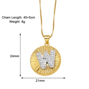 Detail of gold letter W pendant necklace with sunburst pattern and box chain