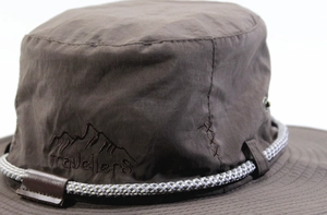 Dettaglio del logo della montagna ricamato e testo travellers su cappello da sole outdoor