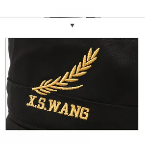 Close-up of golden wheat embroidery and X.S.WANG text on black cotton military cap