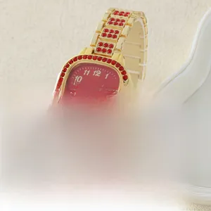 Primo piano dell'orologio dorato di lusso con quadrante rosso e cristalli rossi