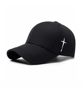 Detail of white cross embroidery on a black cotton baseball cap with curved brim