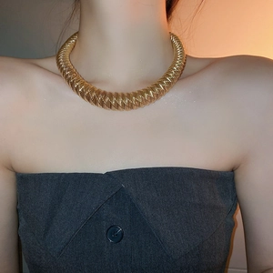 Golden chunky chain collar necklace with woven texture design on model neckline