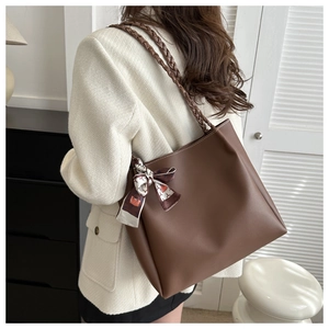 Detailed view of dark brown tote bag with woven handles and decorative silk scarf