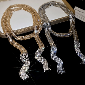Detailed view of rhinestone fringe necklaces in gold and silver with sparkling wave tassels