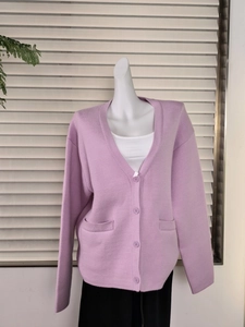 Close-up of purple knit cardigan featuring V-neckline, four buttons and square pockets