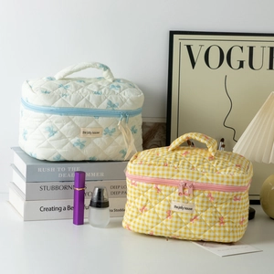 Quilted cotton toiletry bags with bow details and handle for travel organization