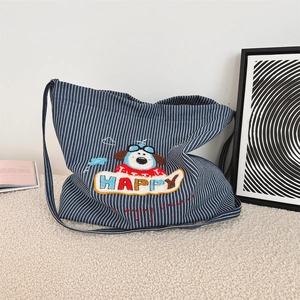 Detail of blue and white striped canvas tote bag with happy puppy embroidery