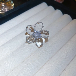 Detailed macro view of a silver floral ear cuff with crystal petals and zircon center