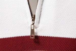 Makro-Detail des Herren-Halbreißverschluss-Pullovers mit weiß-braunem Strickmuster