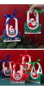 Detail of Christmas gift boxes with 3D Santa and reindeer designs and ribbon handles