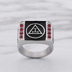 Men's silver stainless steel Masonic ring with red zircon stones on marble background