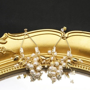 Élégantes boucles d'oreilles dorées avec grappes de perles blanches et cristaux brillants