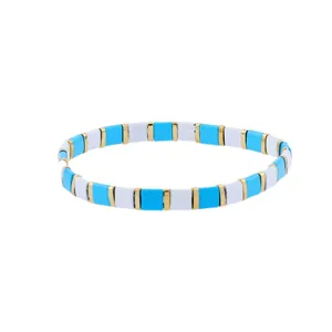 Detail of bohemian stretch tila bead bracelet with blue, white, and gold enamel tiles
