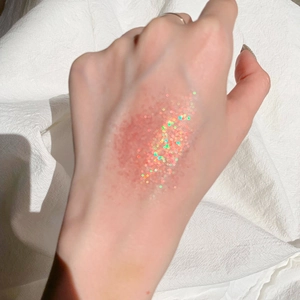 Primo piano di campioni di ombretto glitterato rosa e oro con finitura scintillante sulla pelle