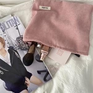 Detailed interior storage of the pink corduroy makeup bag with tools and cosmetics