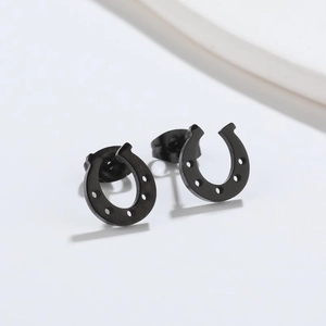 Macro view of minimalist black U-shaped horseshoe stud earrings in stainless steel