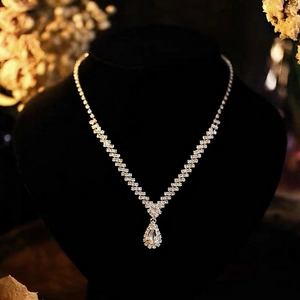 Detailed view of a V-shaped necklace featuring a crystal water drop pendant on a display