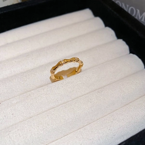 Macro view of adjustable gold bamboo joint ring with zircon stones on display stand