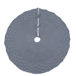 Detail of grey knitted Christmas tree skirt featuring cozy yarn texture and ribbon ties