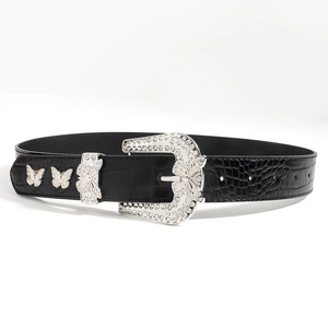 Detail of a black faux-crocodile belt featuring a silver butterfly buckle with rhinestones