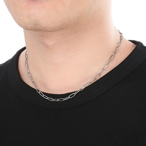 Detail of silver stainless steel paperclip chain necklace worn on neck with white background