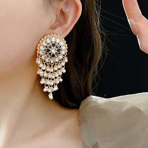 Vintage gold earrings with blue gemstones and white pearl droplets on a model