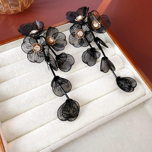 Vue détaillée de boucles d'oreilles pétales noirs à pompons avec strass brillants
