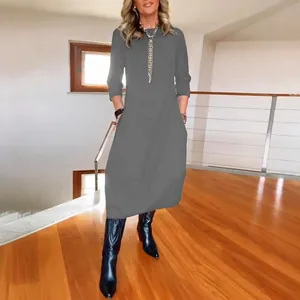 Detail showing the gray long-sleeved midi dress with a loose fit and round neckline