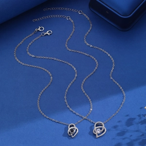 Macro detail of silver heart necklace with projection stone on deep blue velvet back