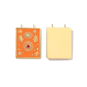 Detailed view of orange enamel rectangle pendants with celestial patterns and gemstones